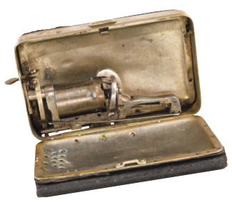 Rare porte-monnaie en métal nickelé et cuir à deux compartiments, un pour le revolver 5 coups, l’autre pour la monnaie. 1877. (10,5 × 7 cm).